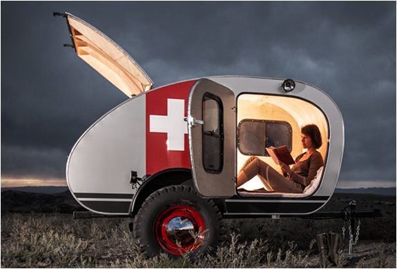 Best Teardrop Trailers - woman reading a book inside a brightly lit vintage overland trailer