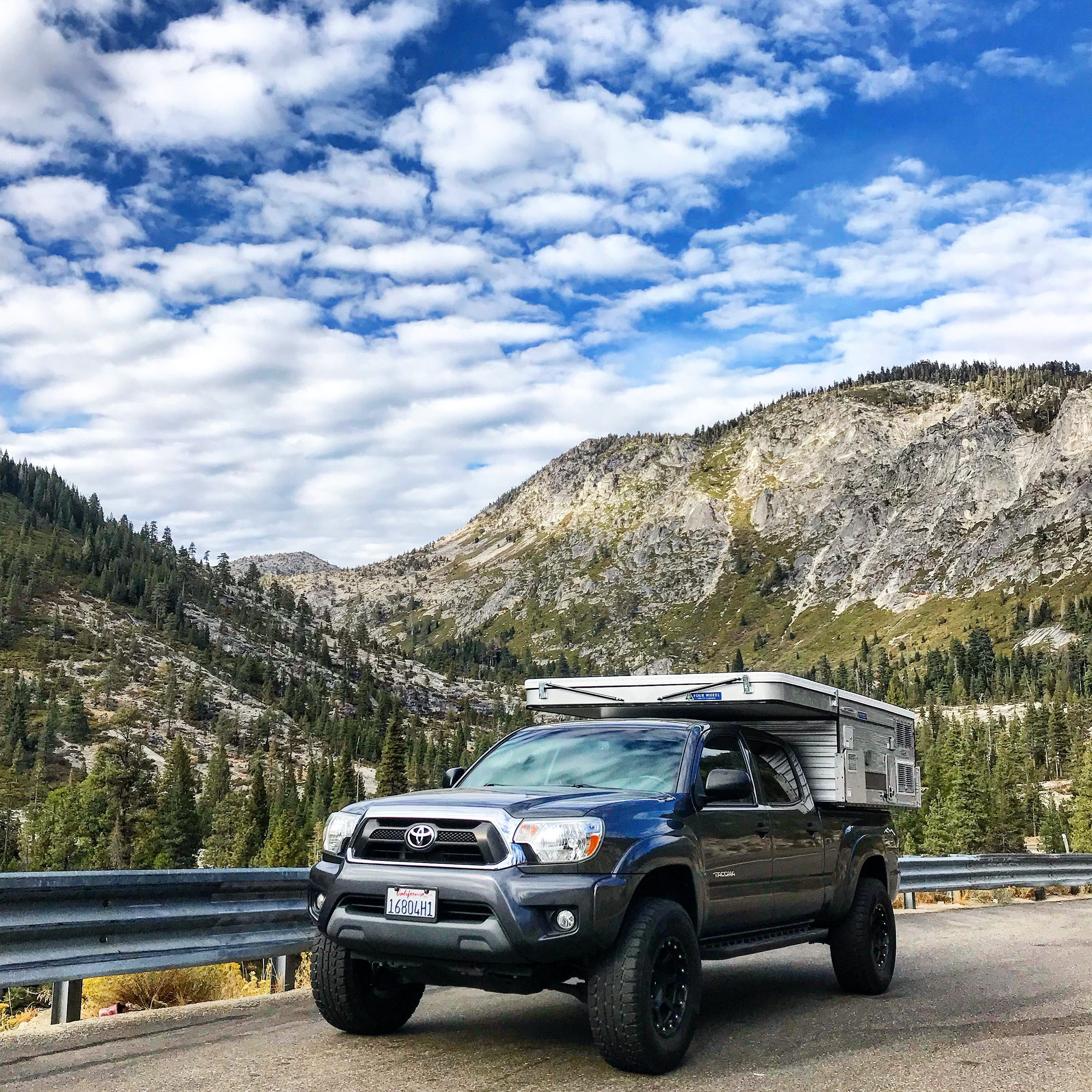 Toyota Tacoma Camper on the way to  Lake Tahoe, with mountains and pine trees in the background