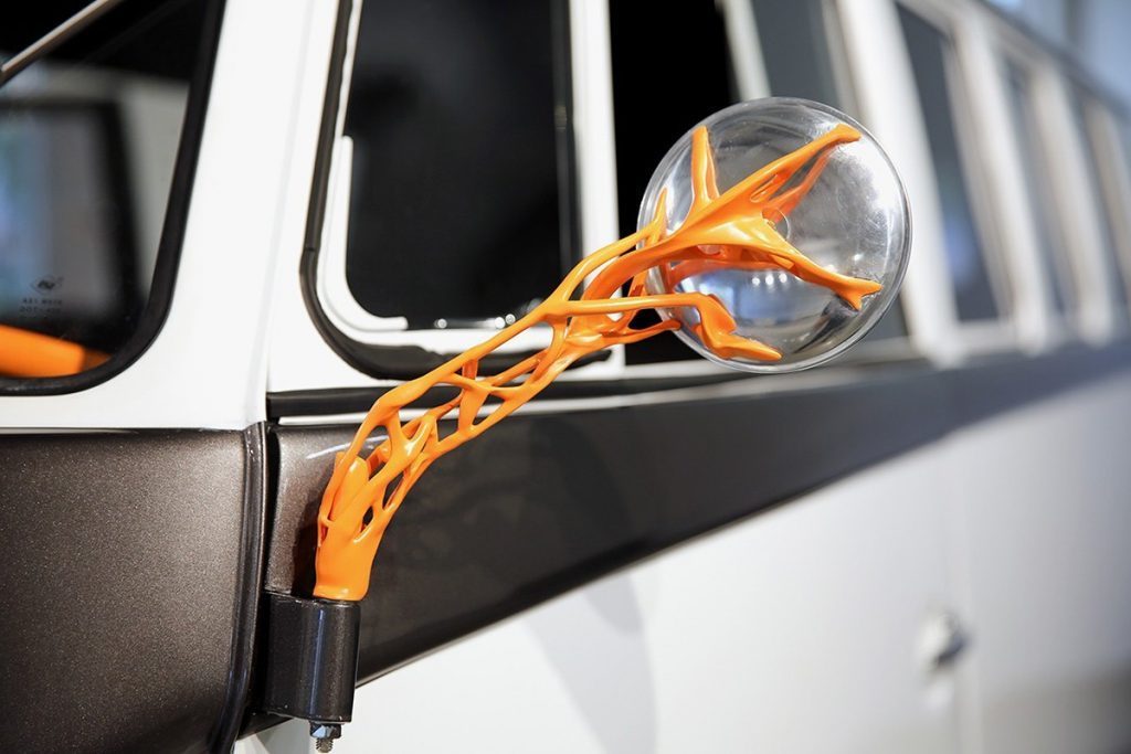 Vw Electric Campervan has orange wing mirror brackets that look like veins on a plant or the branches of a tree