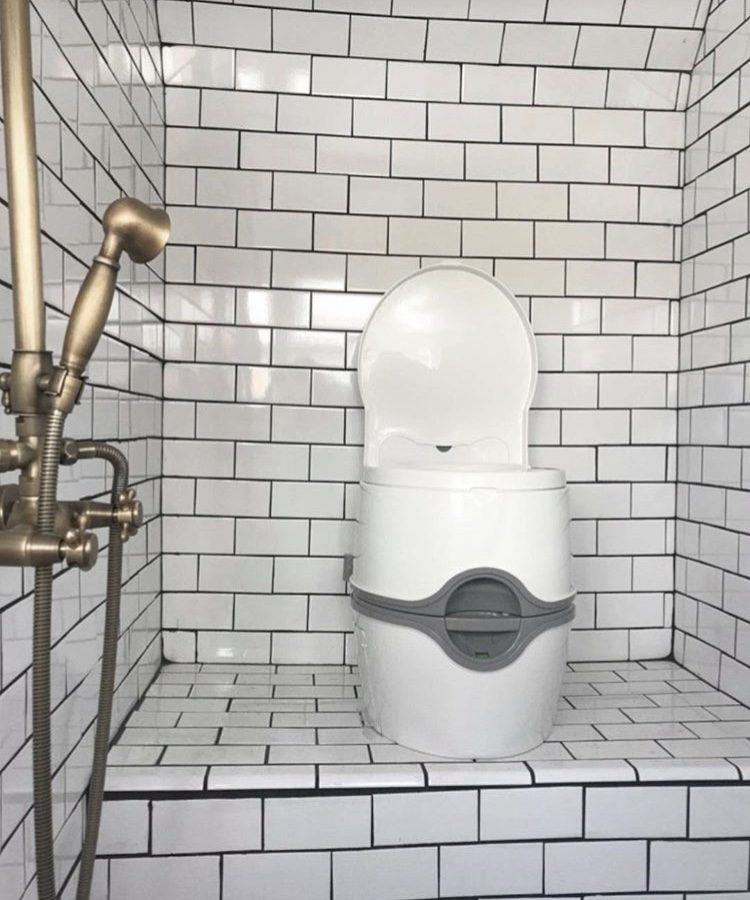 Porta Poti toilet in white tiled bus bathroom. 
