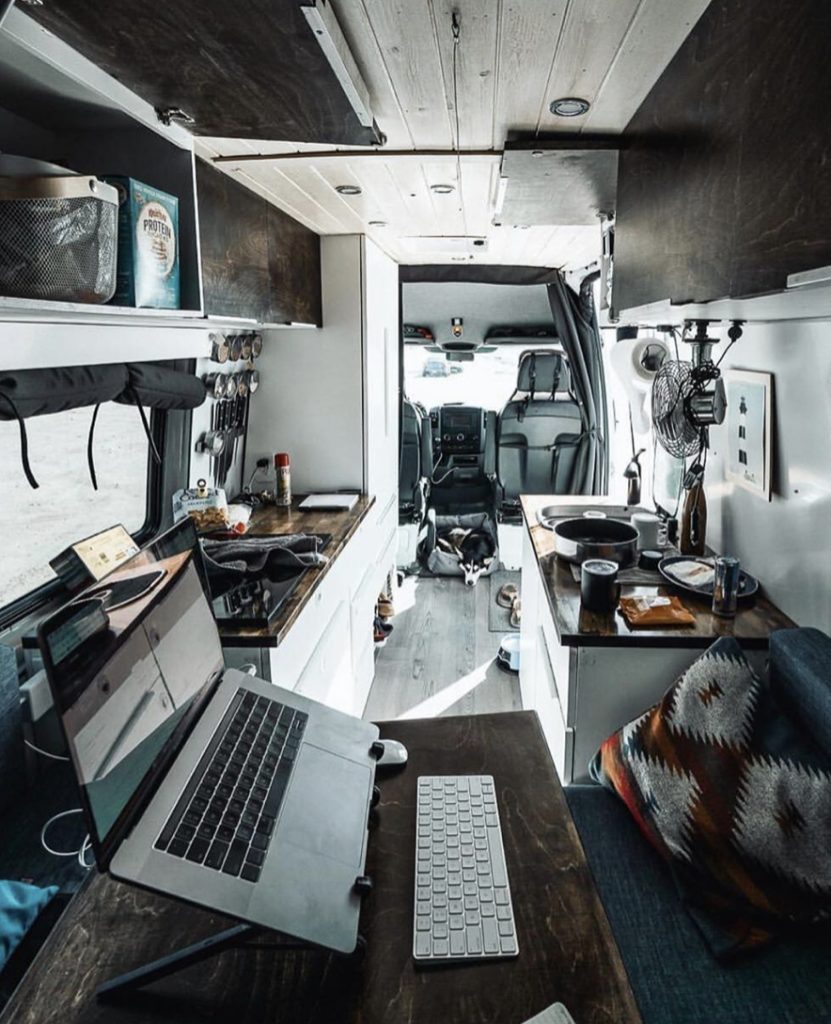 Work station with laptop inside camper van. 