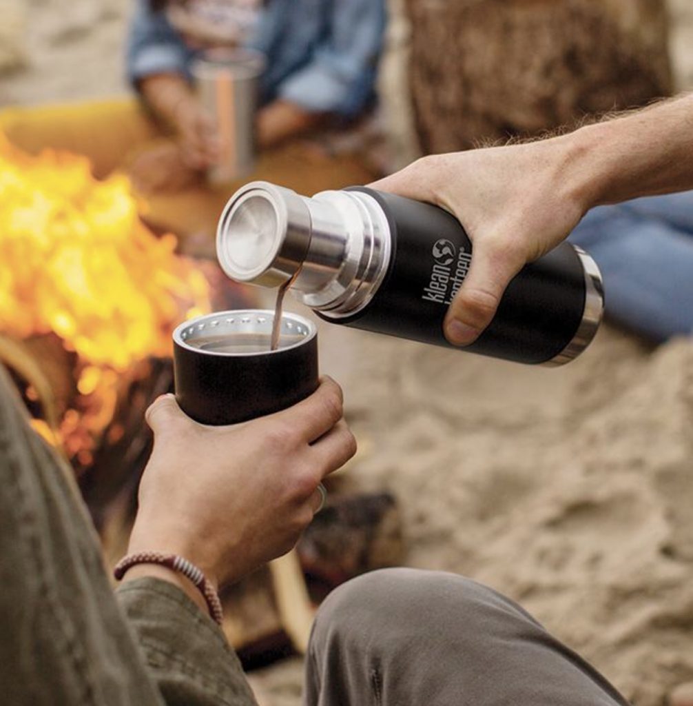 Pouring a drink from a Klean Kanteen by fireside 