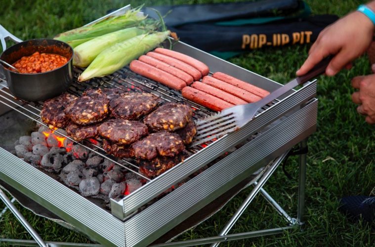 best trailer accessories - a large fire pit with a selection of meat and beans cooking on the top. 