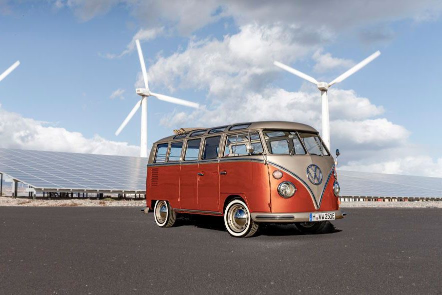 electric microbus with wind turbines in the background