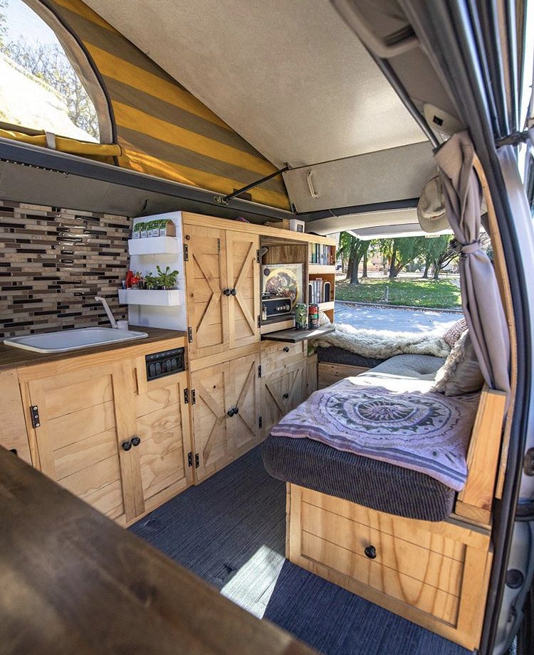 Custom van ideas- wooden cabinetry and bench seat inside van with pop top open. 