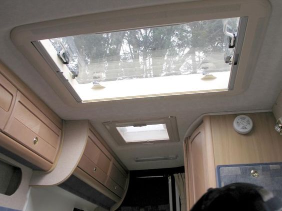 camper van windows - a large skylight with a view of trees above
