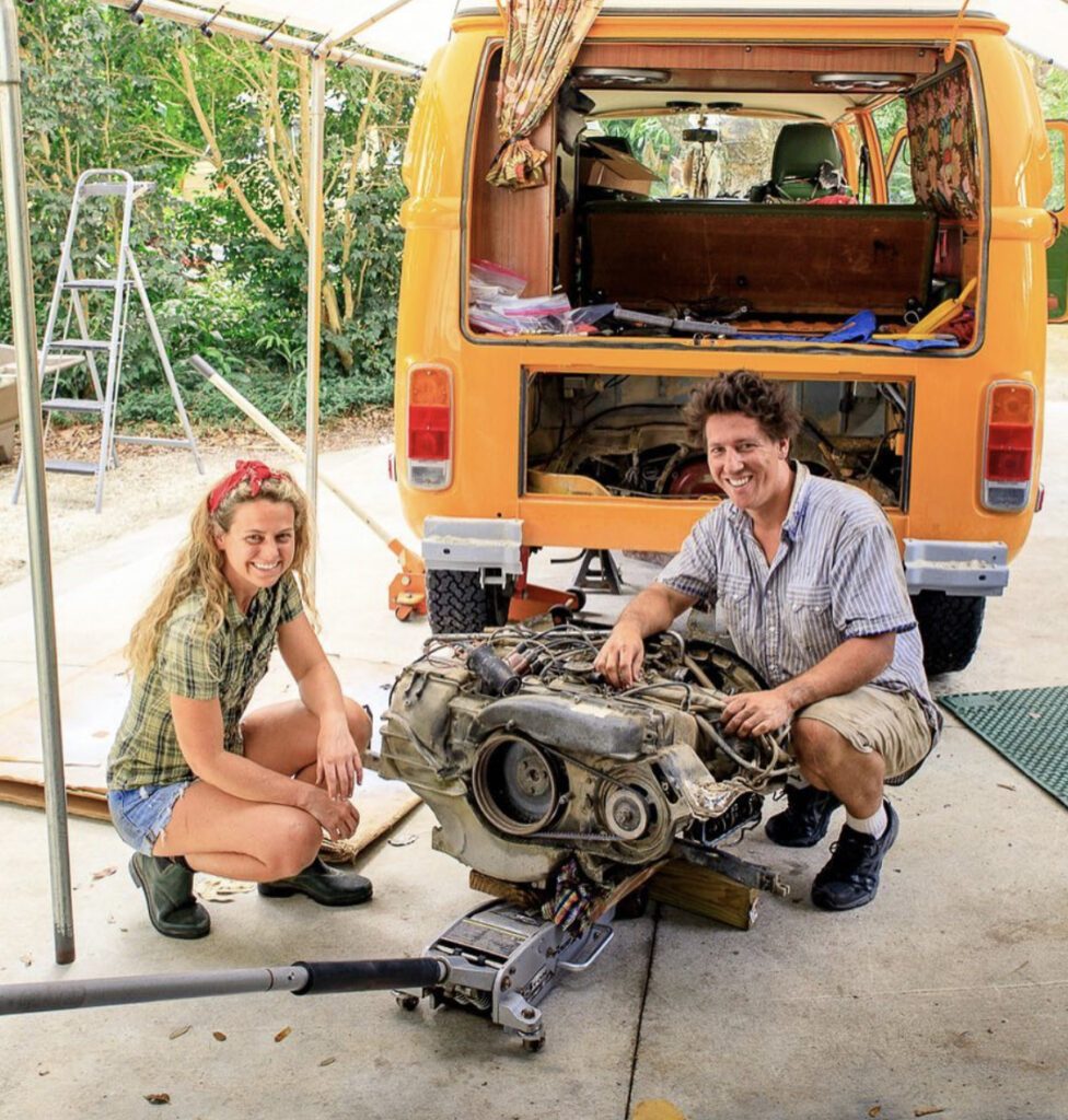 man and woman repairing van’s engine 