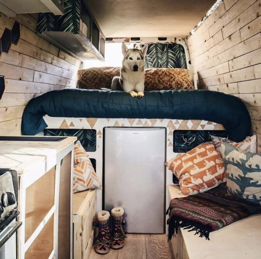 Camper van mattress - van interior with fixed bed and husky on it 
