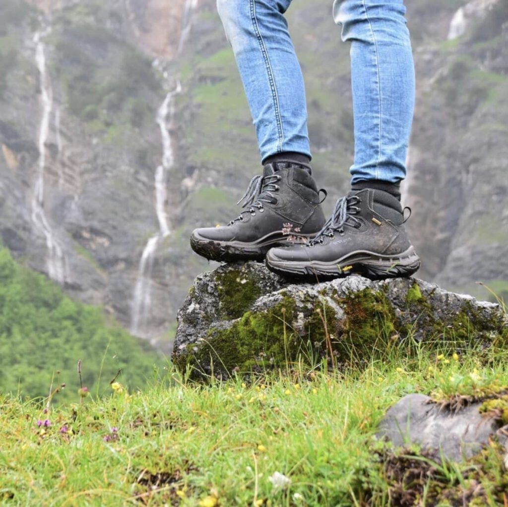 What to bring on a hike : someone wearing hiking boots stood on a rock 