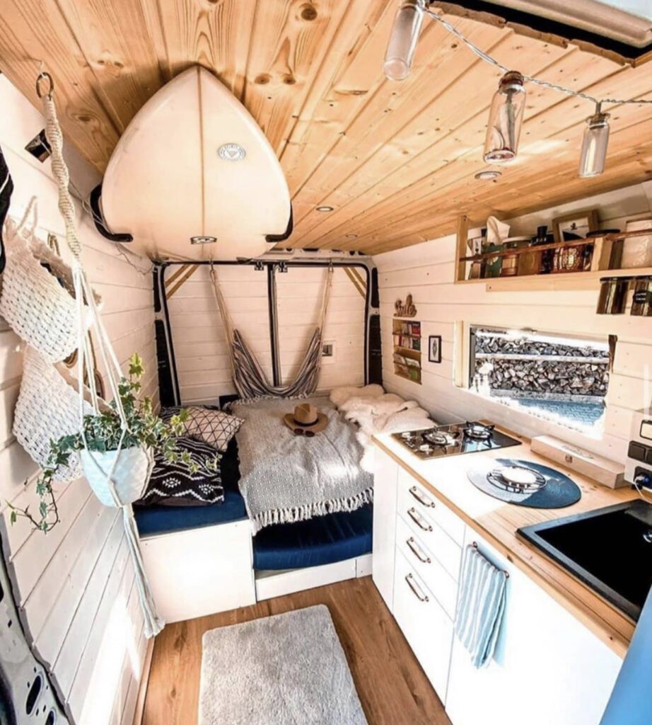 Van home with surfboard attached to ceiling inside 