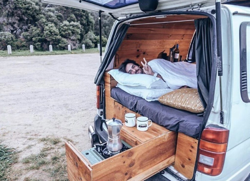Van Camping - Man in bed in van 