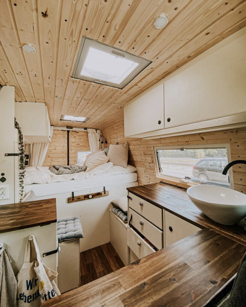 Conversion Vans - Sprinter conversion with wooden walls, fixed bed at back, seating infront and kitchen 